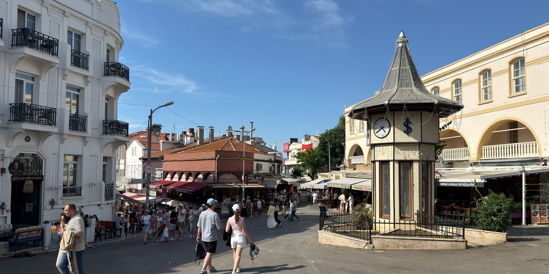 People strolling past the famous clock tower at Büyükada square.