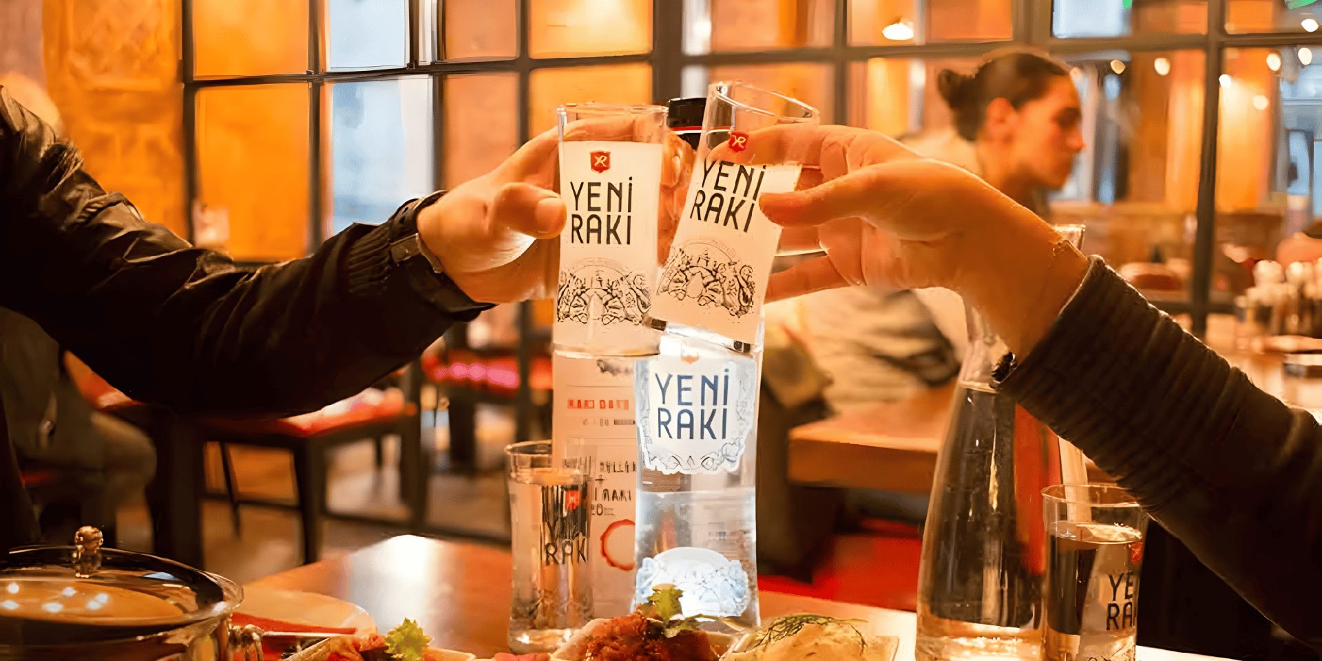 People drinking Yeni raki in restaurant.