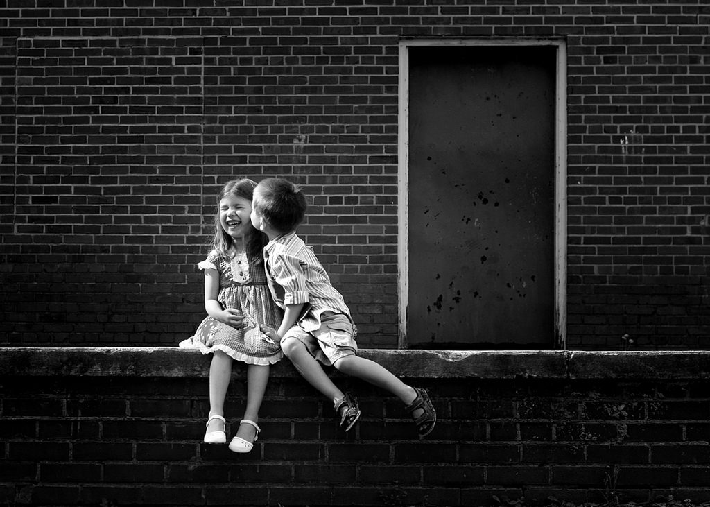 Kids kissing outside.