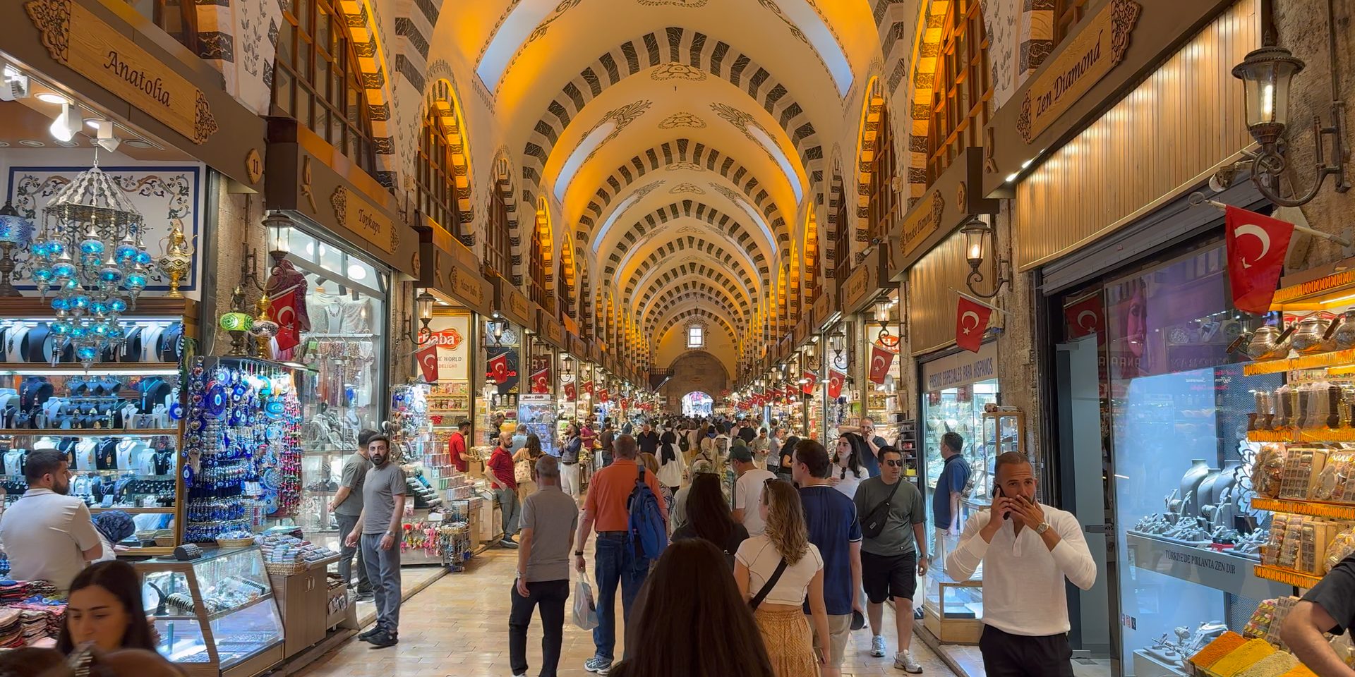 Inside Istanbul's Spice Bazaar (Mısır Çarşısı), a long vaulted hall of striped arches over shops and crowds of shoppers