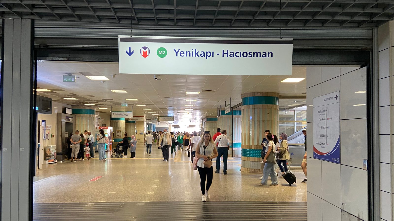 Yenikapı station concourse with overhead M2 sign reading Yenikapı – Hacıosman and tiled columns.