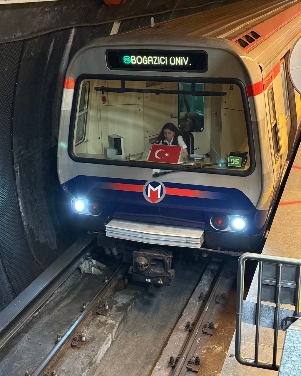 M6 train head-on in tunnel with headlights on, destination display showing BOĞAZİÇİ ÜNİV.