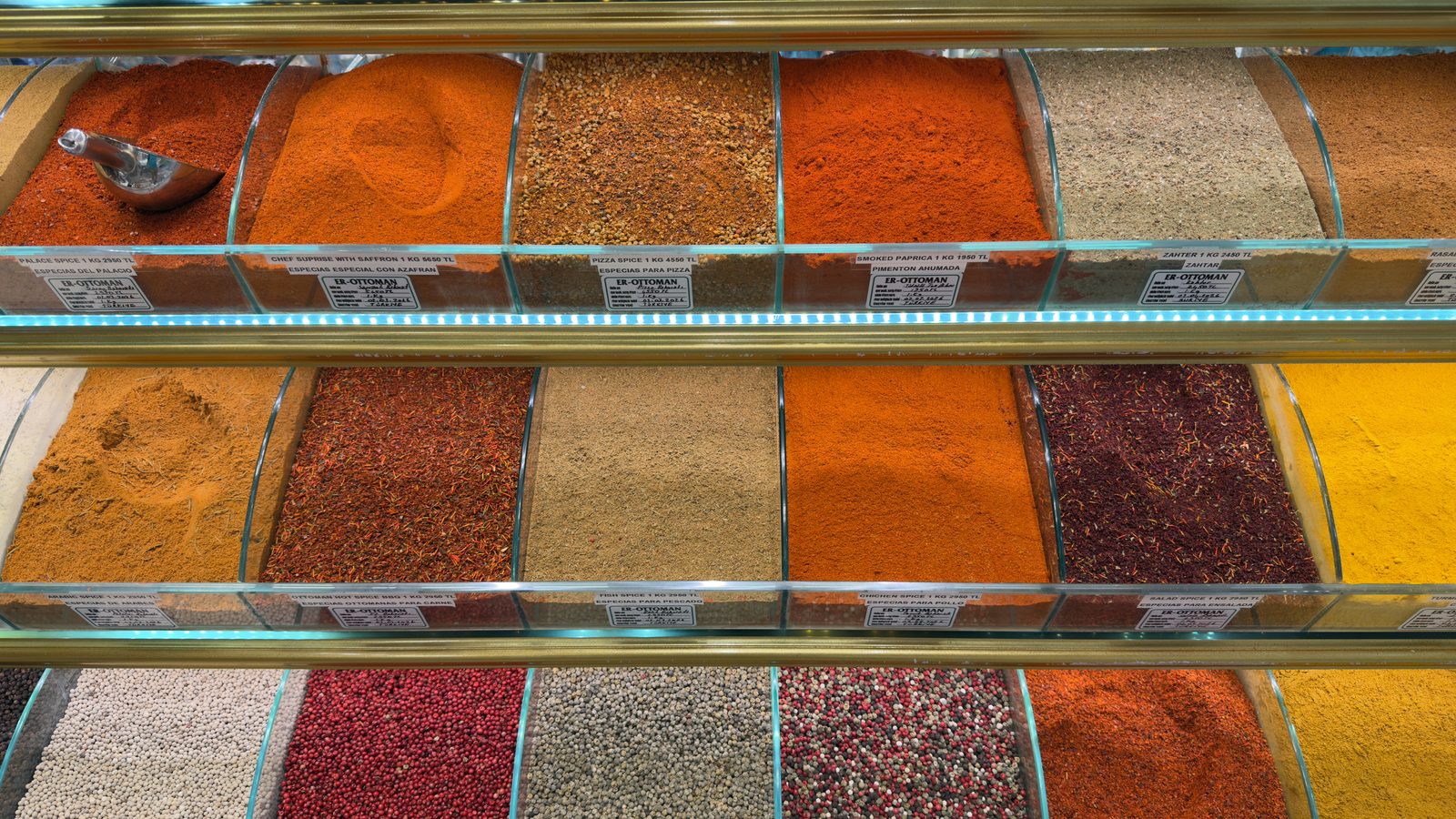 Glass bins of red, orange, yellow and beige ground spices at a Spice Bazaar stall in Eminönü.